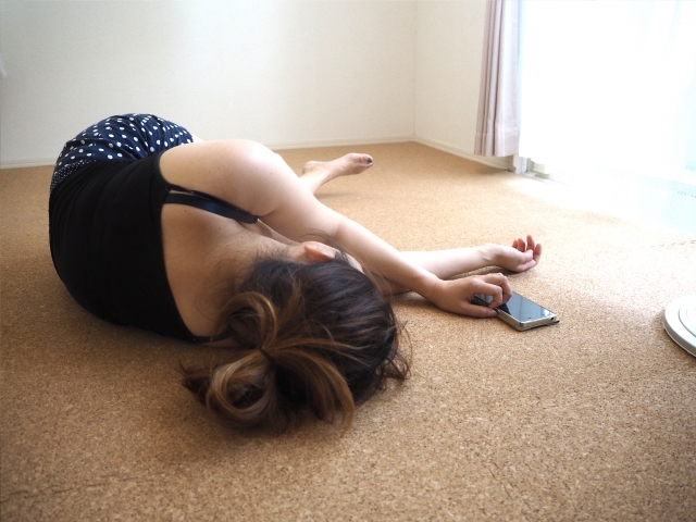 床に寝転ぶ女性